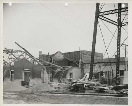 Photograph of people razing the power plant prior to reconstruction in West Liberty