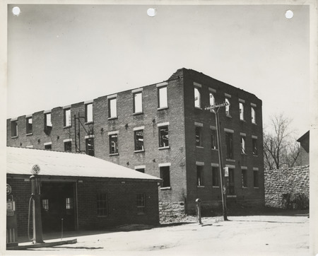 Photograph of a building to be razed at the site for a community building in Bonaparte
