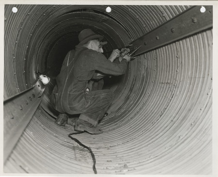 Photograph of people working on a sewer pipe in Webster City
