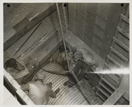 Photograph of people working on a sewer pipe in Webster City