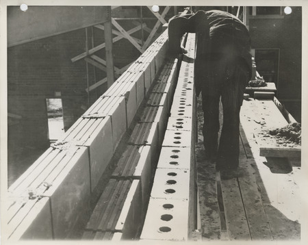 Photograph of a person working on a school building gymnasium addition in Durant