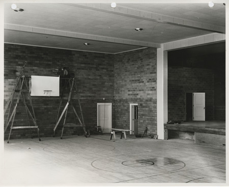 Photograph of interior construction of a school gymnasium in Little Cedar