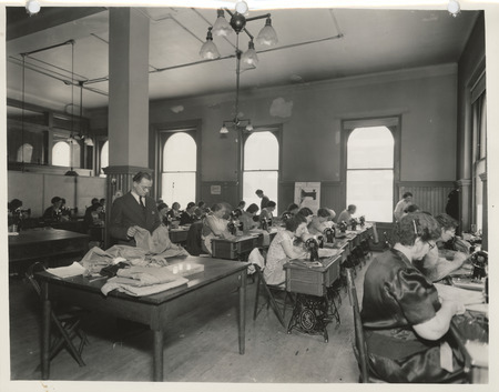 Photograph of people in the machine section of a sewing room in Dubuque