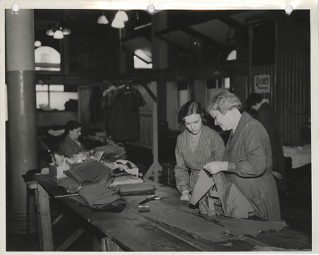 Photograph of people mending old clothing in a sewing room in Dubuque