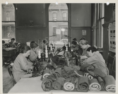 Photograph of people using power machines at a sewing room in Dubuque