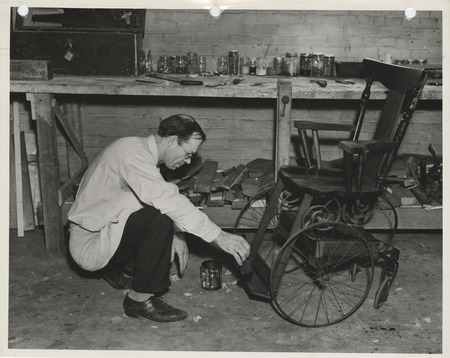 Photograph of a person painting a wheelchair in Dubuque
