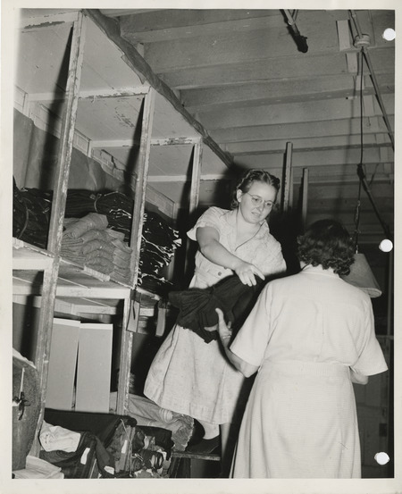 Photograph of women holding the fabric in the stock room in Davenport