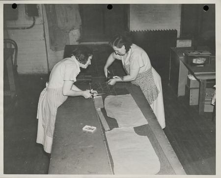 Photograph of women cutting the fabric in the sewing room in Davenport