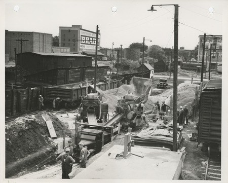 Photograph of people working at the concrete mixing plant for street paving in Fort Dodge